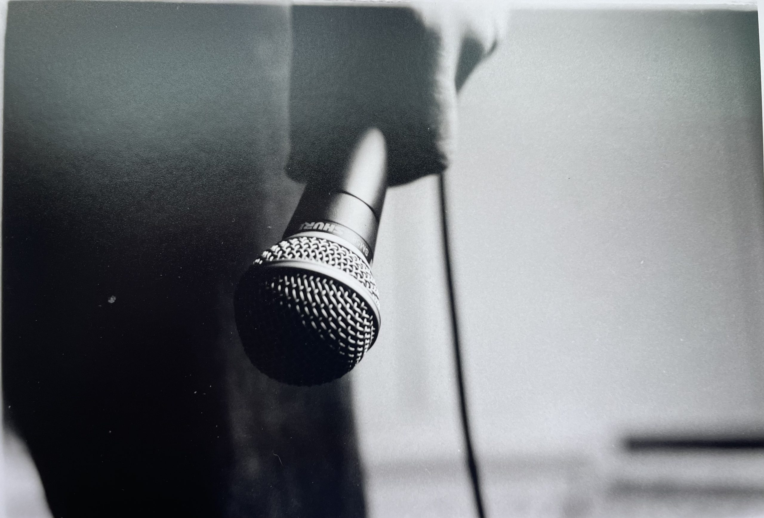 hand holding microphone pointed towards the ground