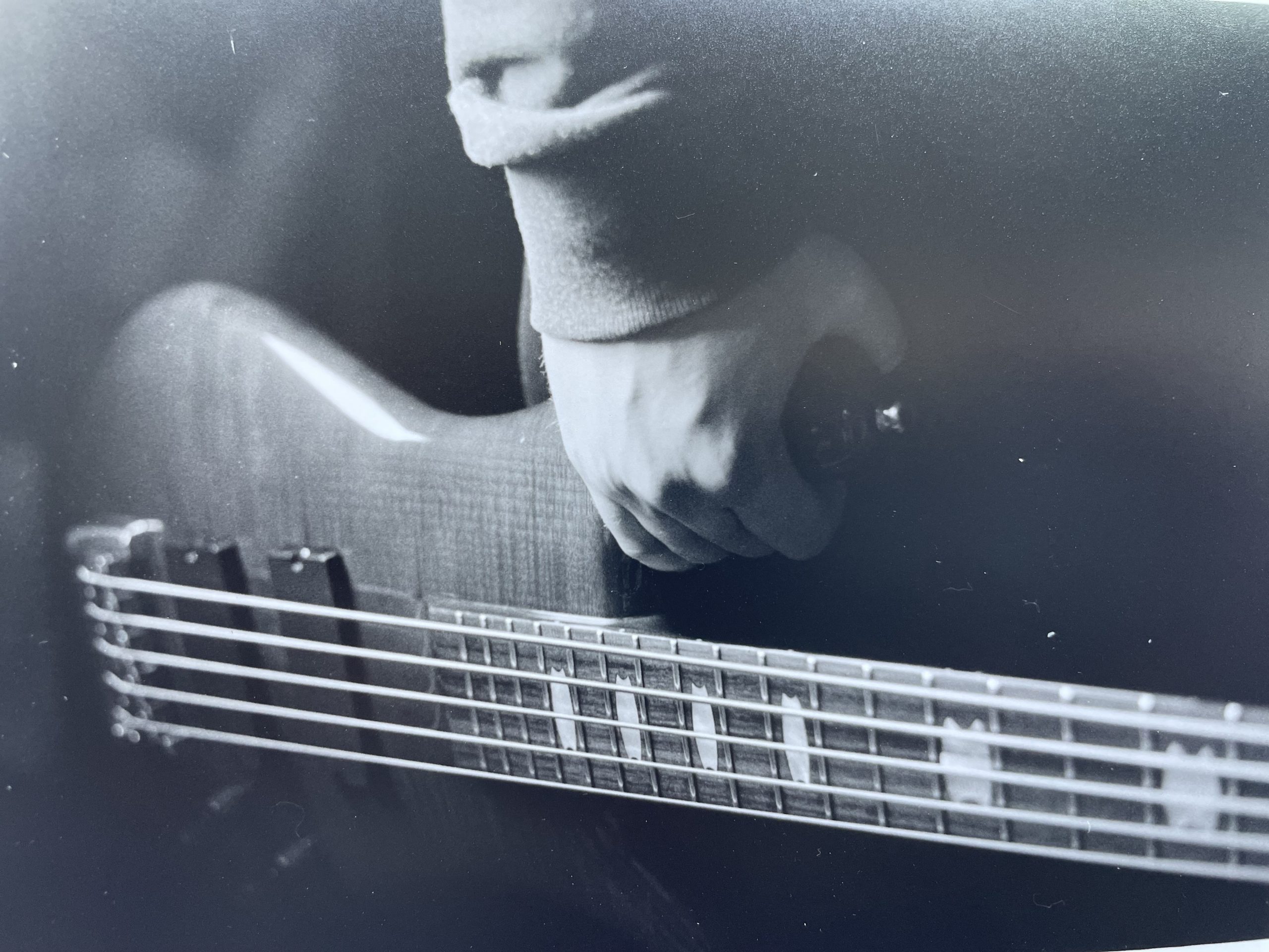 hand holding bass guitar at horizontal angle
